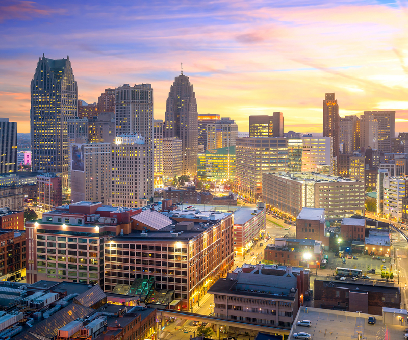 This image showcases a stunning aerial view of a cityscape at dusk. The scene is dominated by numerous skyscrapers, many of which are illuminated, giving the impression of a thriving urban center. The warm hues of the setting sun create a visually appealing contrast with the architectural features of the buildings, potentially highlighting the desirability of properties within the area.