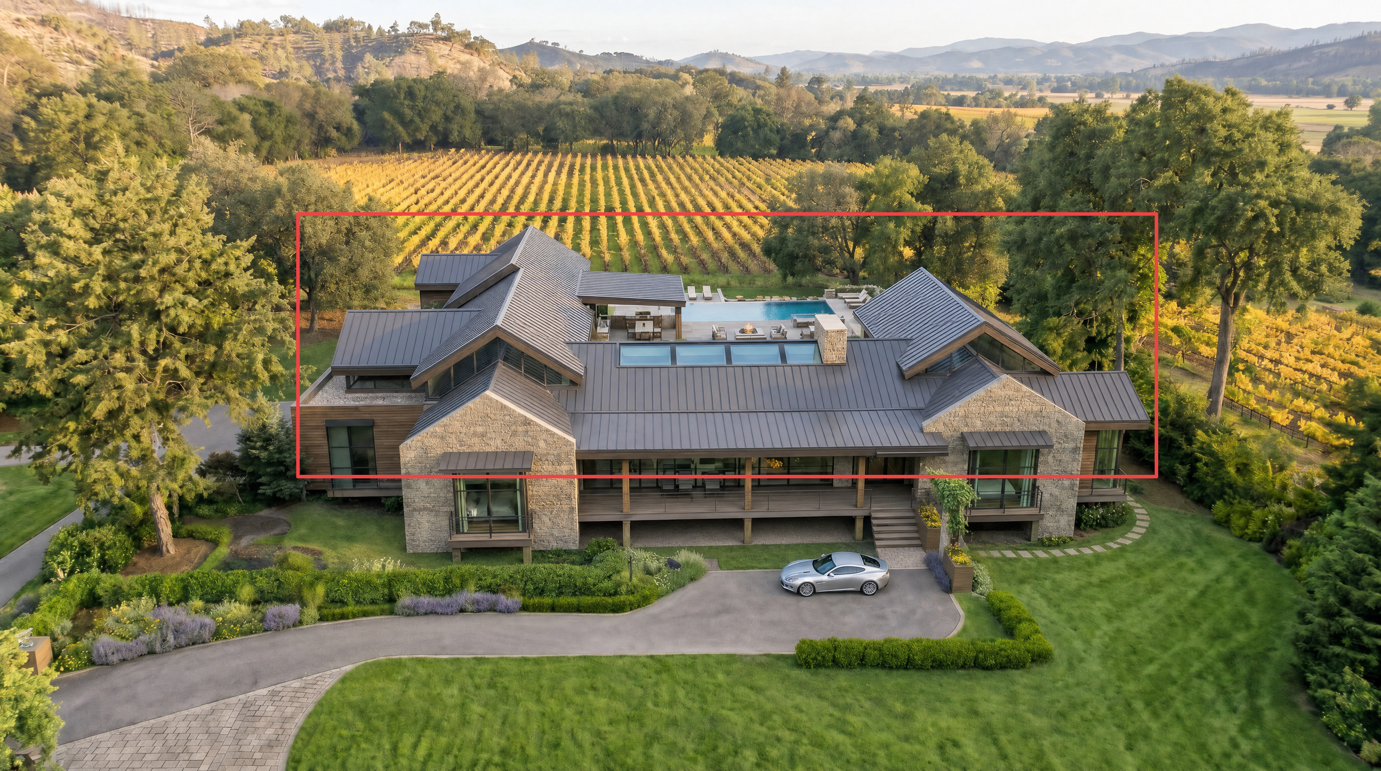 This stunning contemporary estate features a sophisticated blend of stone and metal construction, seamlessly integrated into a sprawling vineyard landscape. The aerial perspective highlights a private swimming pool, expansive outdoor terrace, and a multi-gabled roofline, creating a luxurious and harmonious architectural statement. The property's scenic setting, combined with its high-end exterior finishes, suggests a premier, secluded retreat.