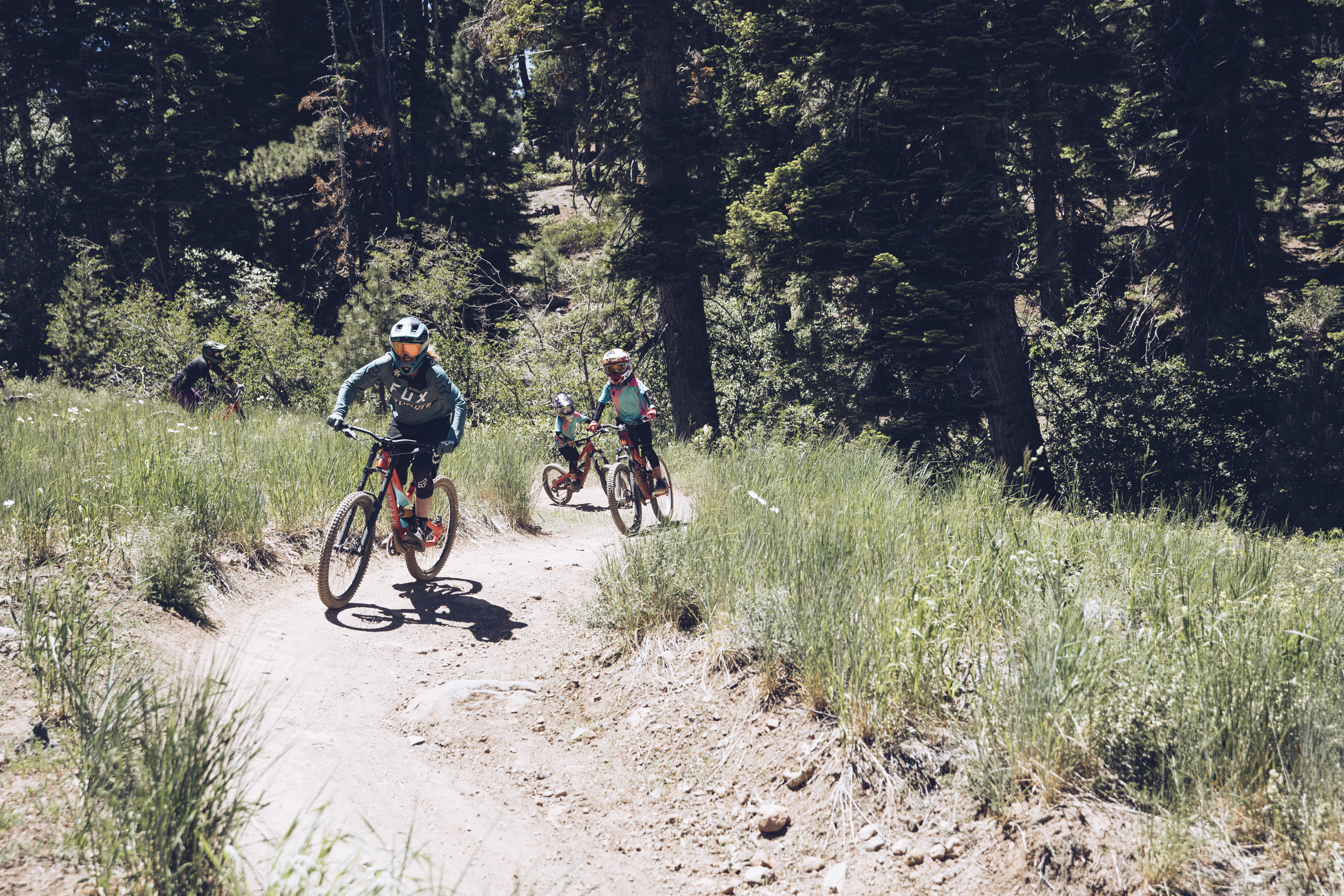 This image highlights recreational outdoor living, featuring a group of mountain bikers riding along a well-maintained trail in a forested landscape. The setting emphasizes the active lifestyle opportunities provided by local nature trails and parks, adding value through recreational amenities. It showcases a natural, scenic environment perfect for outdoor enthusiasts.