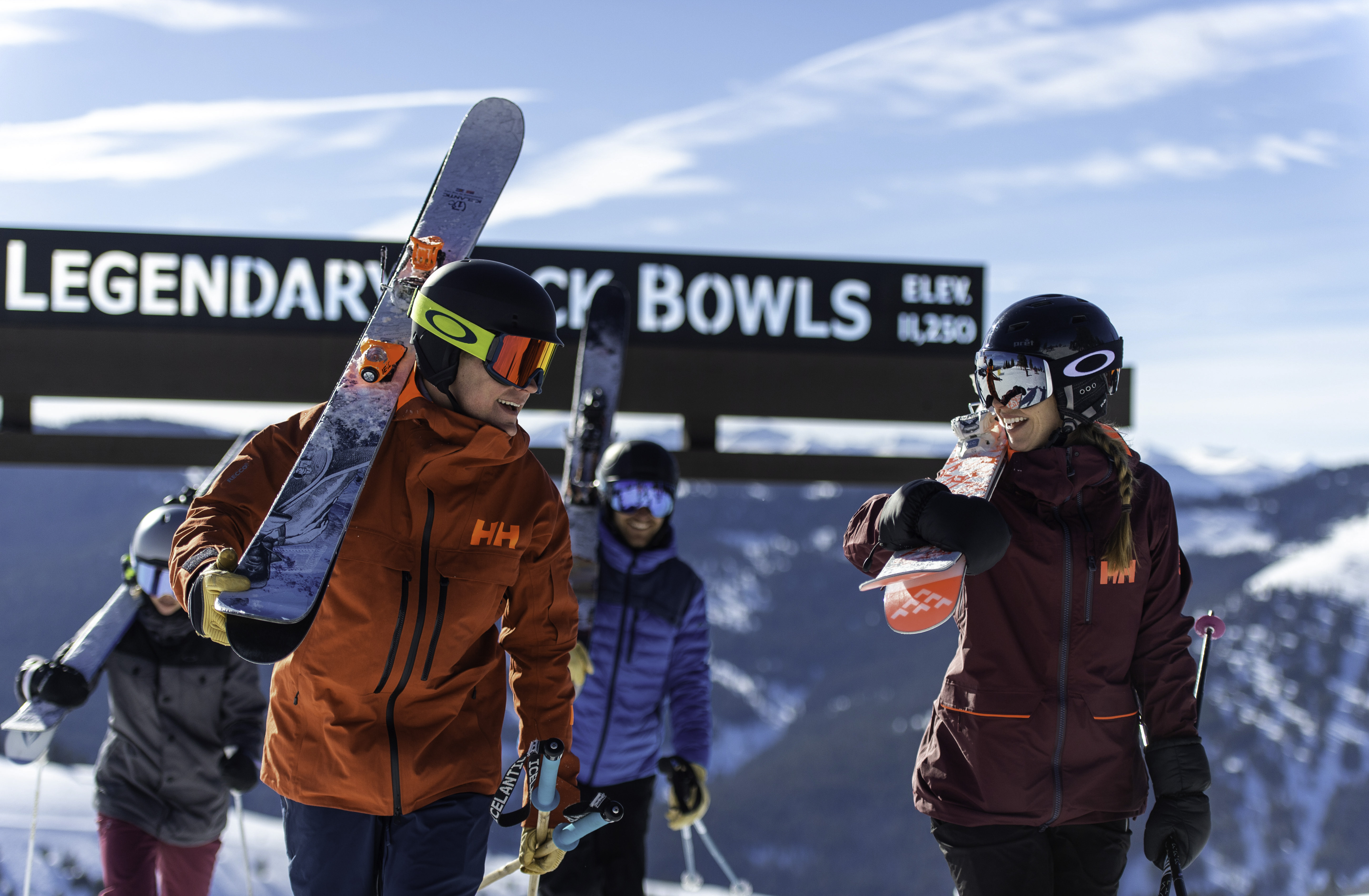 This image showcases a group of skiers enjoying a day on the slopes. The photo includes a sign reading "Legendary Bowls” indicating a feature of the community. The background reveals beautiful mountain views, an attractive element for a property near this location.