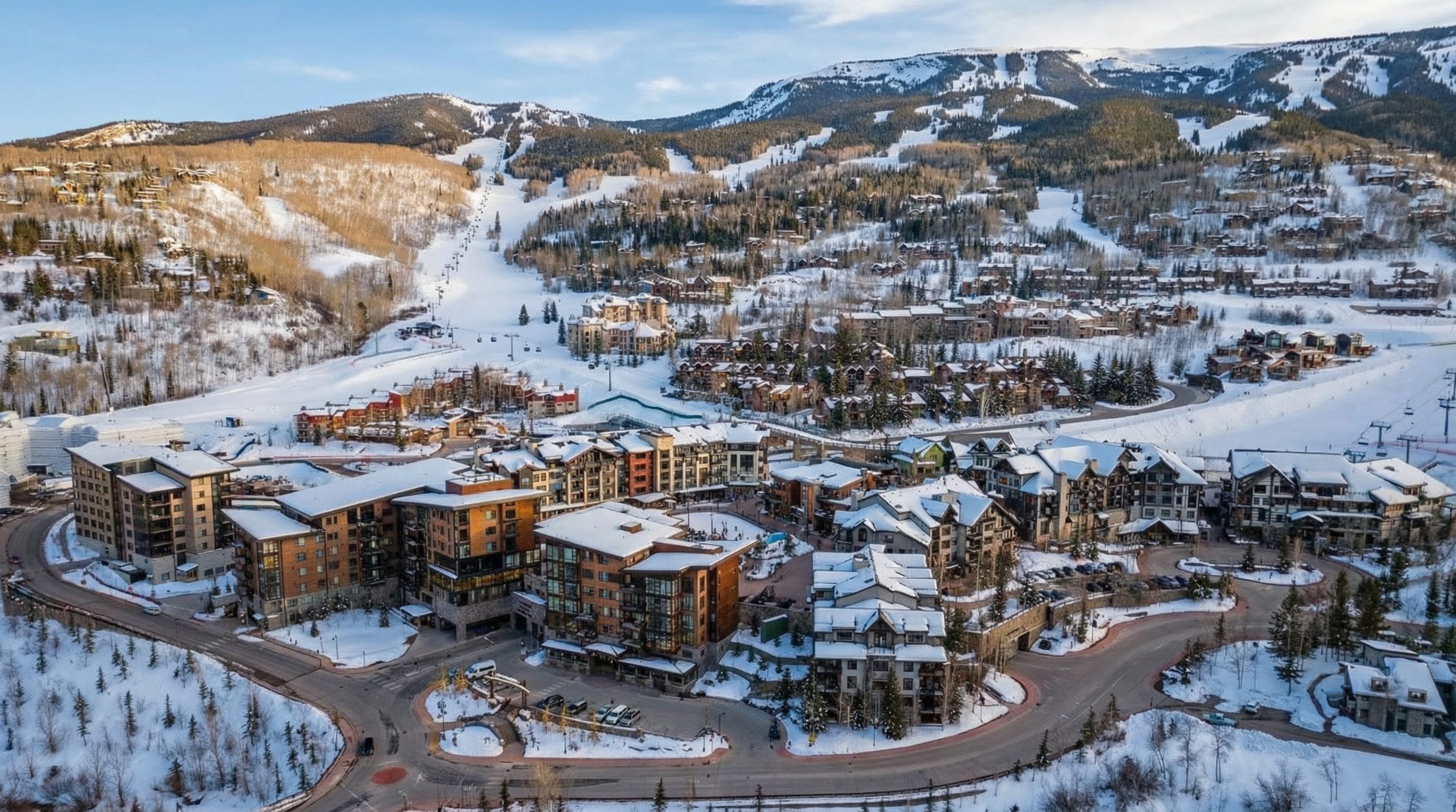This aerial view showcases a luxury ski resort town nestled in a snowy mountain landscape. The image highlights多棟 buildings with snow-covered roofs, winding streets, and surrounding trees. The overall impression is one of a high-end, picturesque winter getaway destination, suitable for real estate listings targeting affluent buyers.