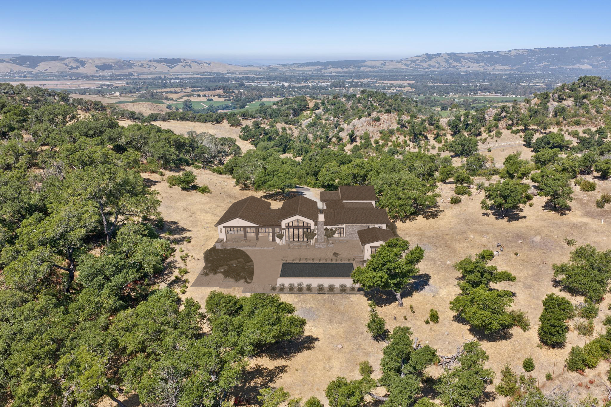 This high-altitude aerial view showcases a luxury modern estate integrated into a vast, rolling landscape of oak trees and dry grasses. The residence features a complex roofline and a prominent central glass-paned gable, complemented by an outdoor living area with a rectangular swimming pool. The property offers an expansive, serene setting with panoramic views of the distant valley, emphasizing privacy and architectural integration with the natural environment.
