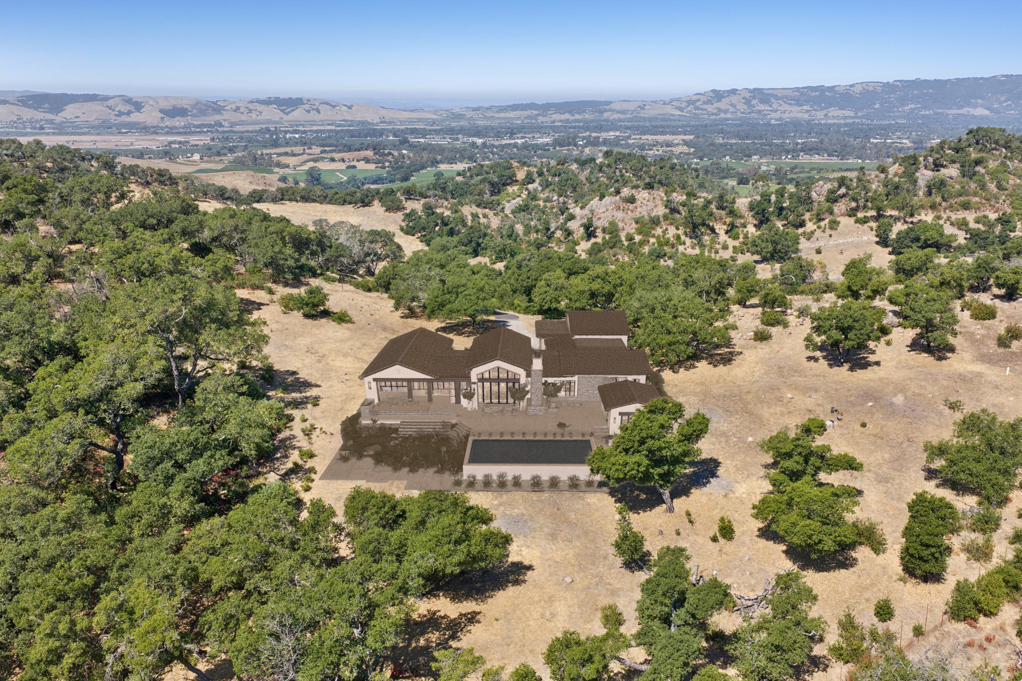 This high-angle aerial view showcases a sprawling luxury estate nestled within a scenic, hilly landscape covered in oak trees. The residence features an intricate roofline and a large swimming pool situated on a tiered stone terrace overlooking the vast valley beyond. The architectural style suggests a modern farmhouse aesthetic, perfectly integrated into the natural, rural environment.