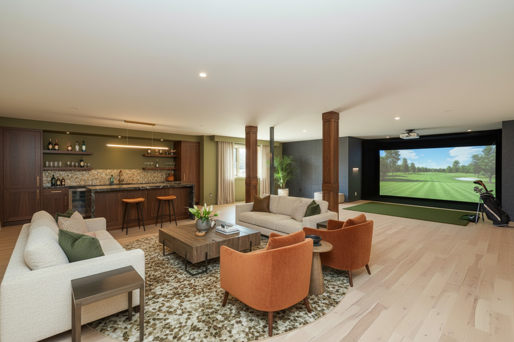 This is a spacious and inviting living room featuring a bar area, comfortable seating, and a golf simulator. The room is well-lit and has a modern design with warm wood accents and a neutral color palette. The golf simulator adds a unique entertainment element to the space.