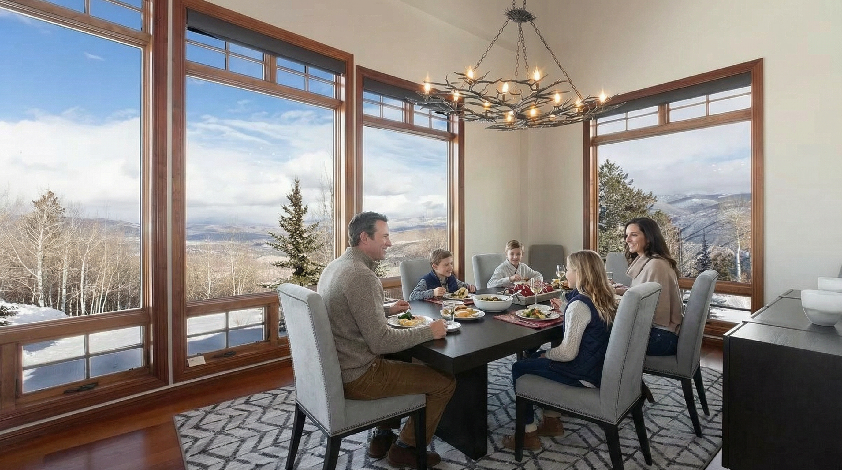 This is a well-lit dining room featuring large windows with a picturesque view. The room is furnished with a dark wood table and upholstered chairs. A unique, branch-like chandelier hangs above the table, adding an artistic yet rustic touch to the interior design.