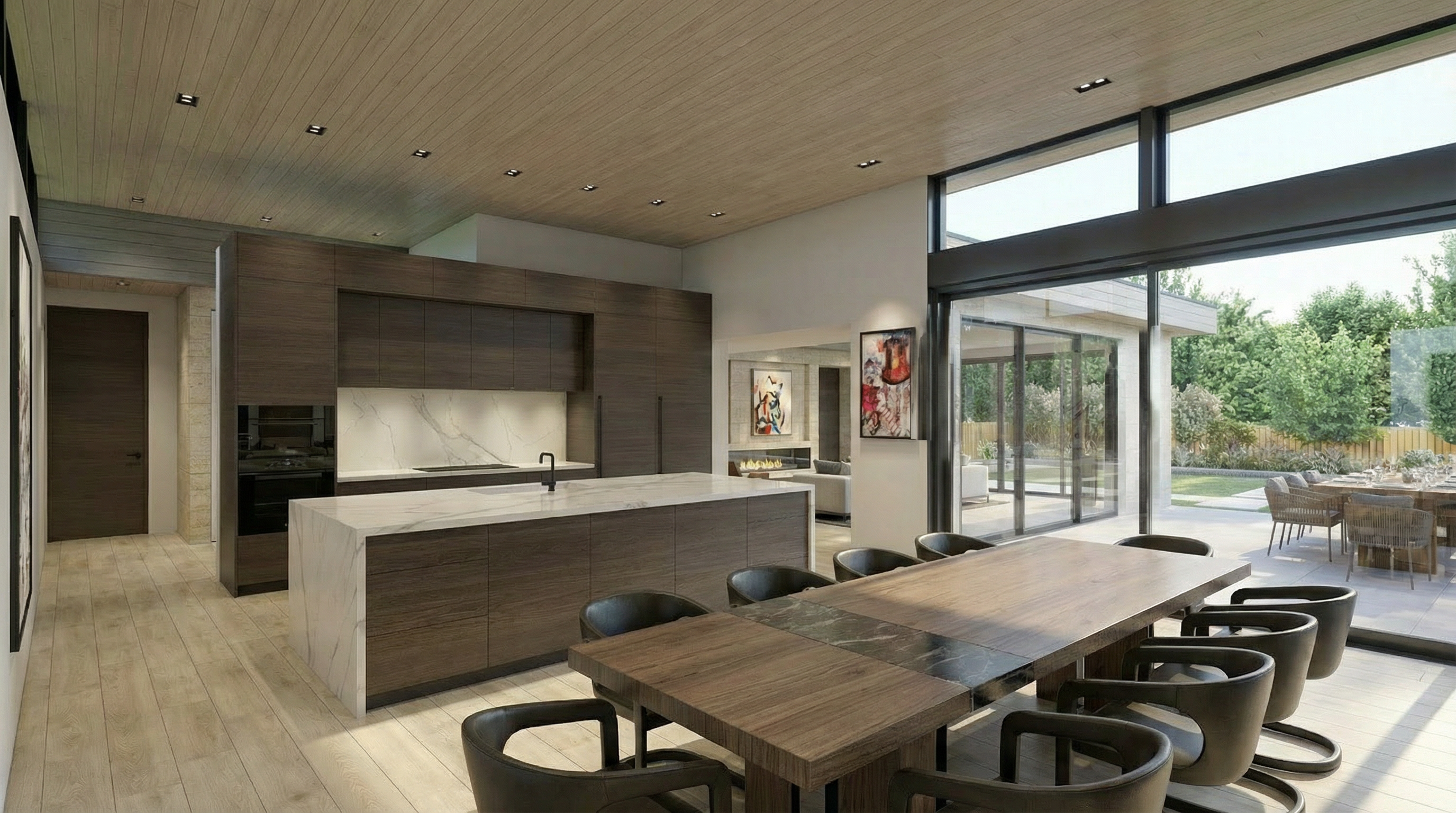 This modern open-concept space features a sleek kitchen with dark wood cabinetry, a large marble waterfall island, and integrated appliances. The adjoining dining area is furnished with a spacious wooden table and contemporary chairs, all connected to a bright, airy patio through floor-to-ceiling glass sliding doors. High-end finishes, including light hardwood floors and a wood-paneled ceiling, contribute to the sophisticated, contemporary atmosphere.