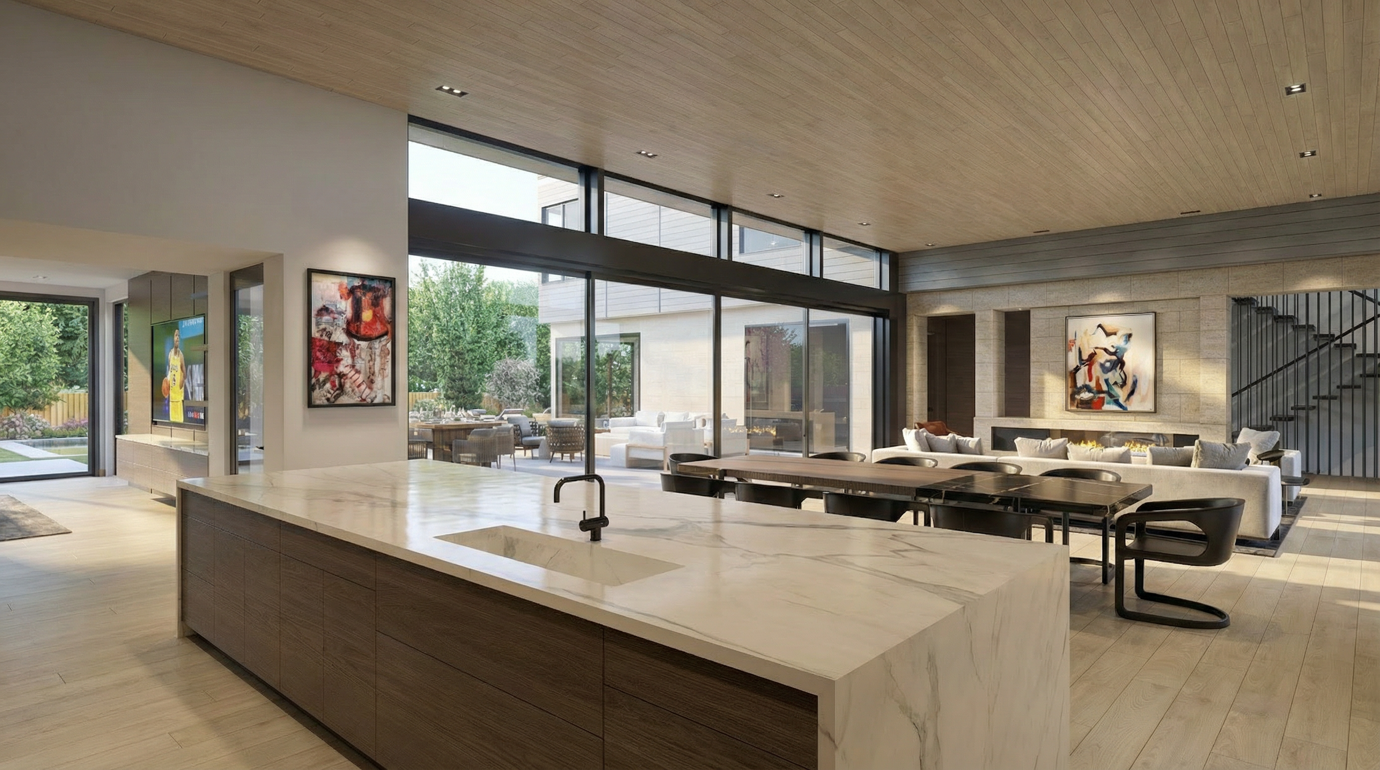This stunning open-concept modern kitchen features a massive marble-top waterfall island and sleek wood cabinetry. The space seamlessly flows into a dining area and living room, illuminated by expansive floor-to-ceiling windows that offer a clear view of the rear outdoor living space. High-end finishes and warm wood-toned ceiling paneling contribute to an elegant and sophisticated atmosphere.