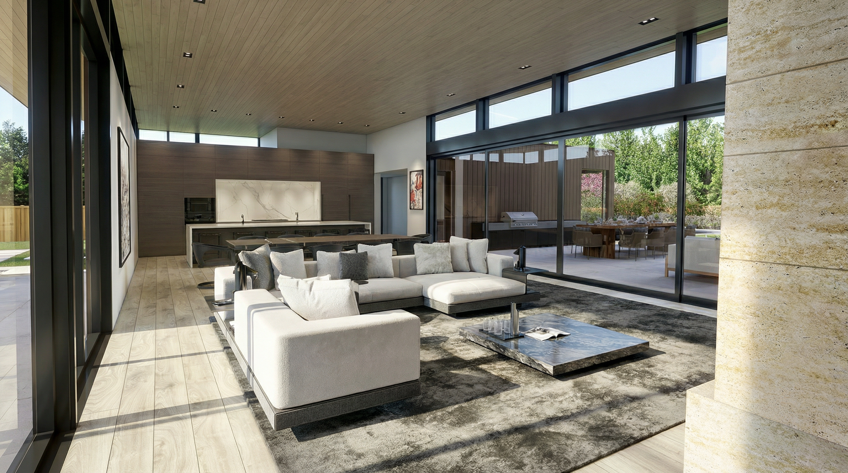 This modern open-concept living area seamlessly integrates with an outdoor patio through large floor-to-ceiling glass sliding doors. The room features a spacious, plush sectional sofa arranged atop a large textured rug, complemented by a low-profile marble coffee table and sophisticated wood-paneled ceilings. The adjacent kitchen features sleek, minimalist cabinetry, creating a cohesive and luxurious contemporary living space.