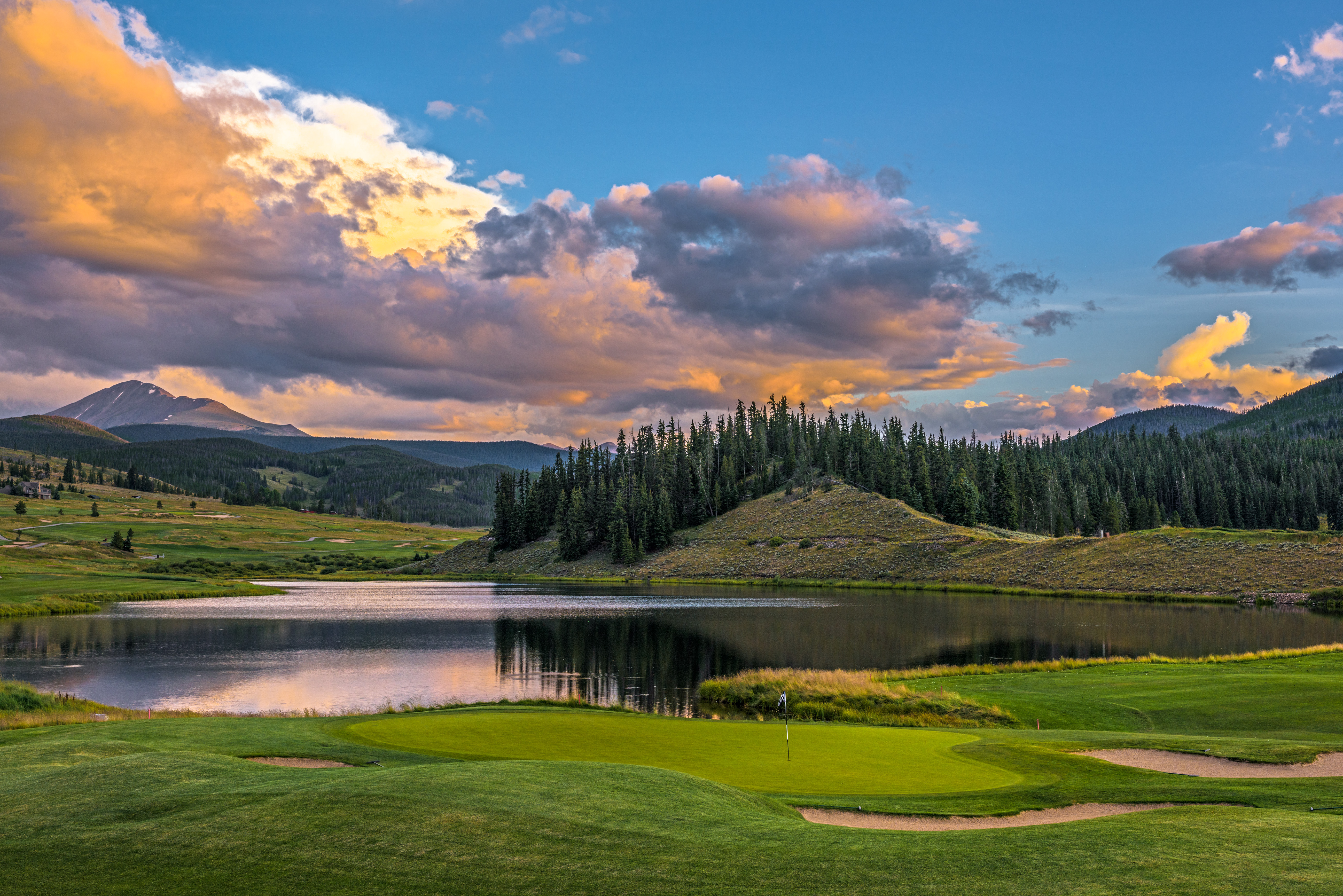 This image showcases a beautiful golf course, likely part of a real estate development or community. The lush green fairway and serene lake create an appealing landscape. This amenity will attract golf enthusiasts and nature lovers, adding significant value to properties within the community.