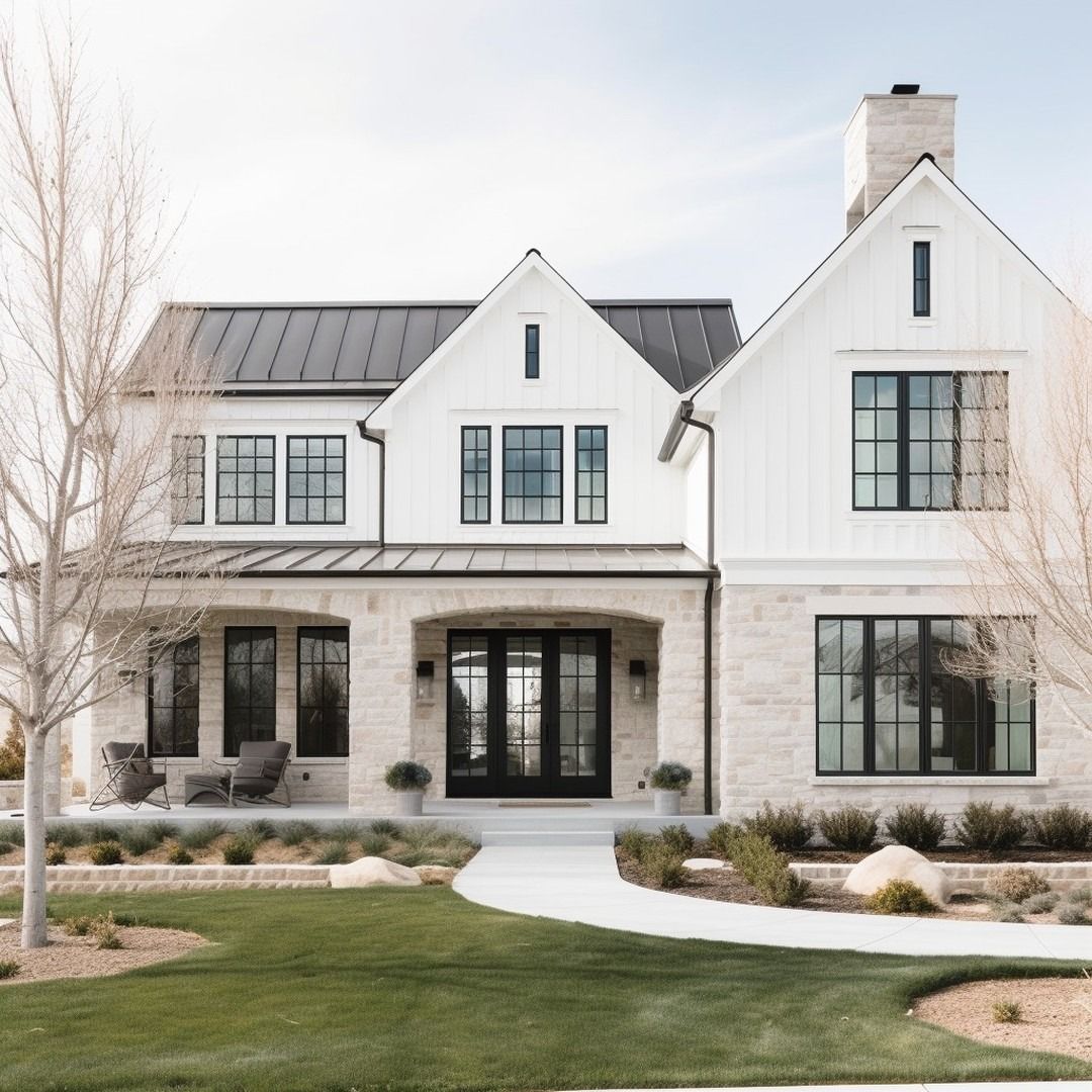 This modern farmhouse features a striking mix of white board-and-batten siding and light-toned natural stone masonry. A prominent covered front porch with arched openings creates an inviting entryway, complemented by high-contrast black window frames and a matching metal roof. The property is finished with professional landscaping, including a manicured lawn and clean hardscaping, contributing to its sophisticated and upscale curb appeal.
